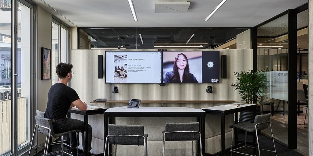 Modern meeting space in Sydney with a person video conferencing