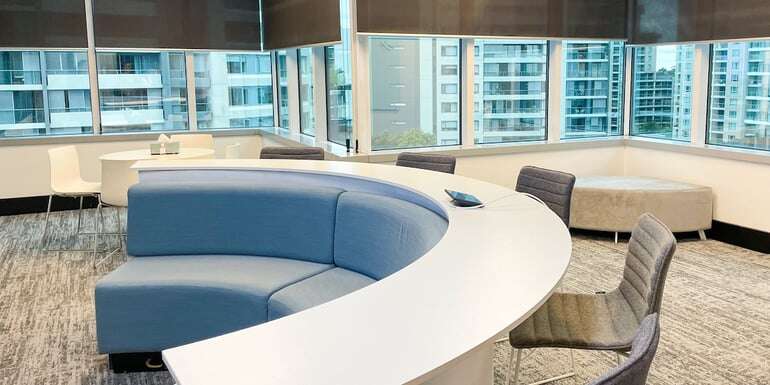 grey chairs windows curtains blue couch desk collaboration area