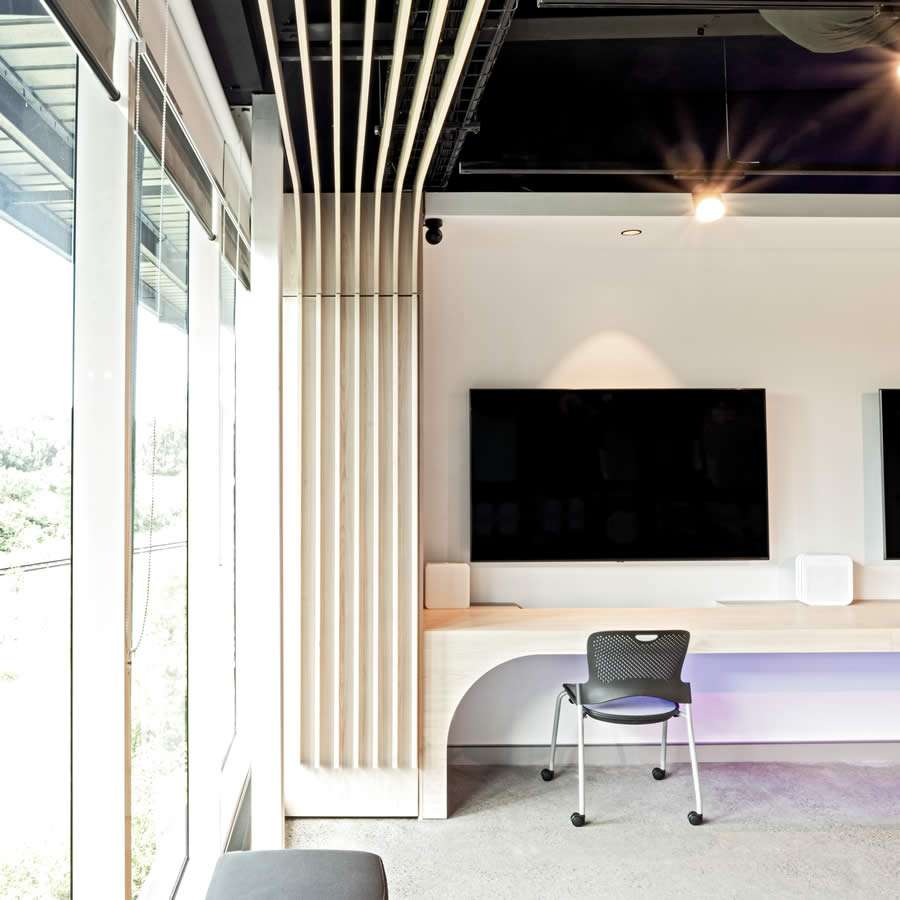 Modern office interior featuring minimalist design, large windows, and a sleek desk with dual screens, promoting a productive work environment.