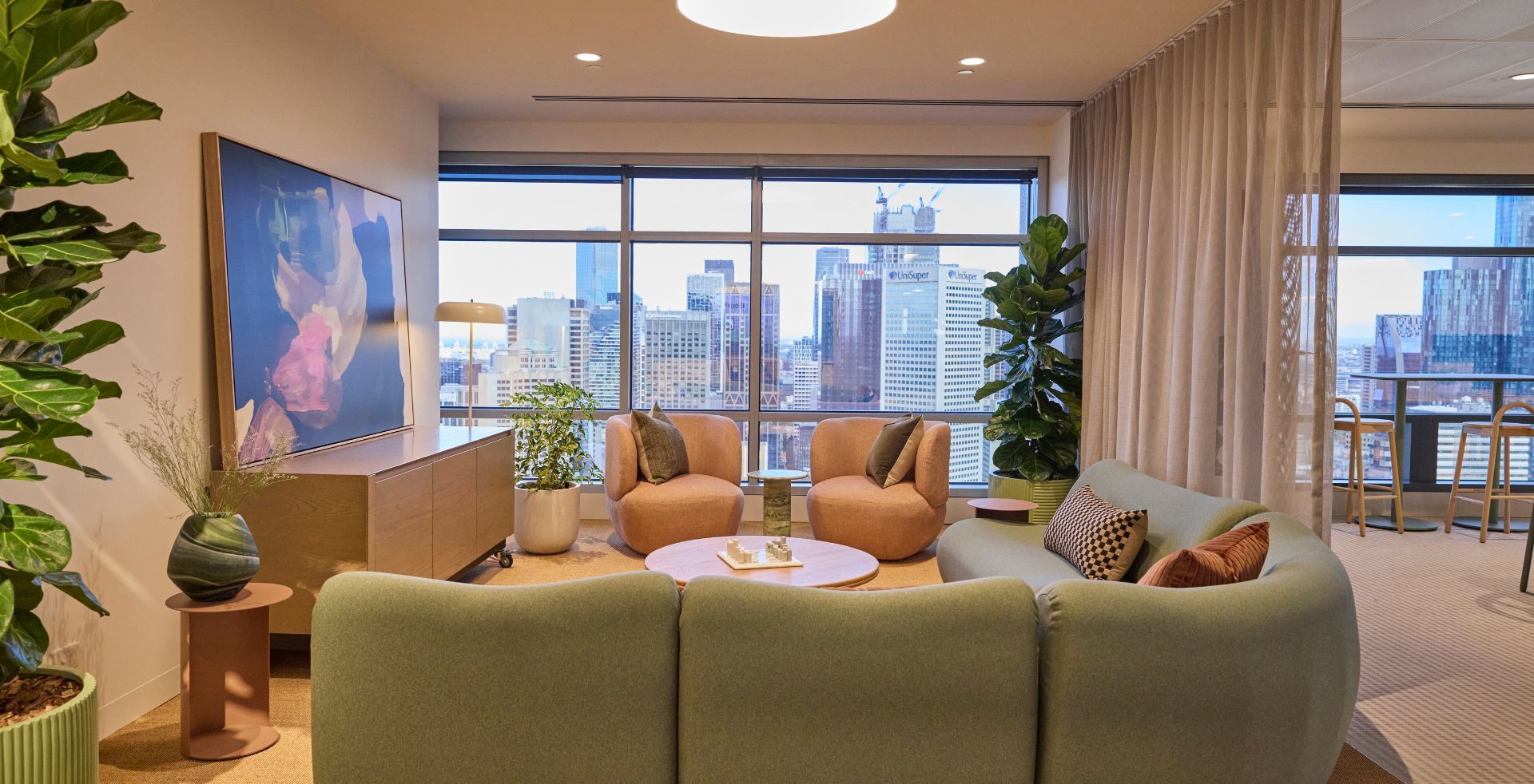 Quiet lounge area with soft furnishings, curated artwork and panoramic city views.