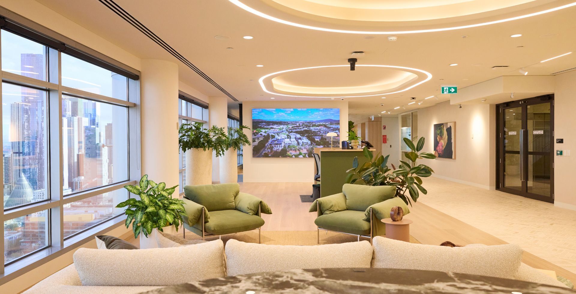 Client-facing lounge and reception space at Knight Frank Melbourne, combining natural materials, integrated planting and expansive city views to create a welcoming arrival experience.