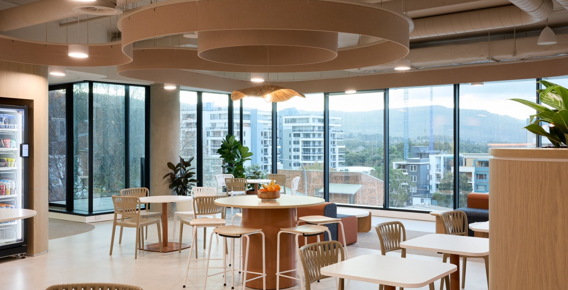 Light-filled breakout area in IRT’s Wollongong office with flexible seating and views of the Illawarra escarpment