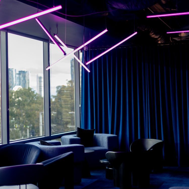 Guests relaxing in the neon-lit lounge at The Great Escape, delivered by Amicus in Melbourne