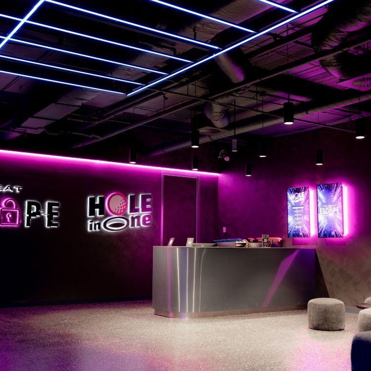 Entry counter beneath backlit branding at The Great Escape, hospitality fitout by Amicus