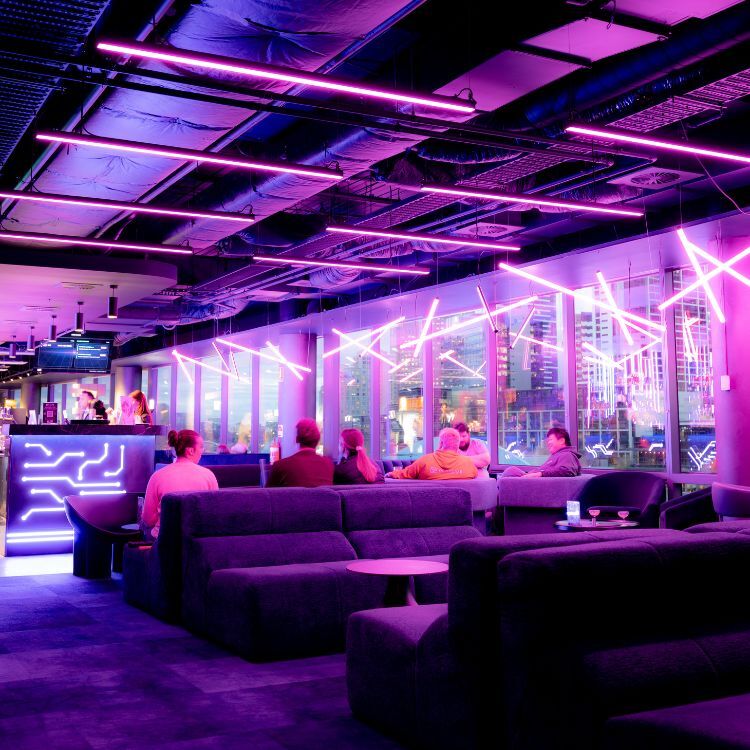 Neon battens and city outlook above lounge chairs at The Great Escape, Melbourne CBD venue