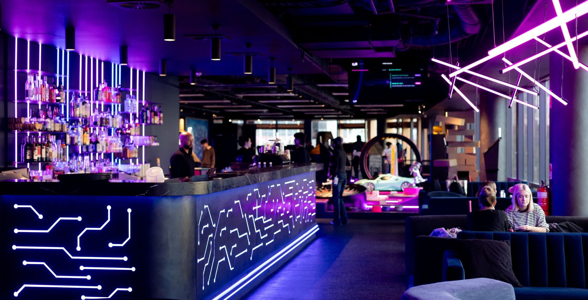 Backlit spirit shelving and circuit-board bar front at The Great Escape Melbourne, built by Amicus