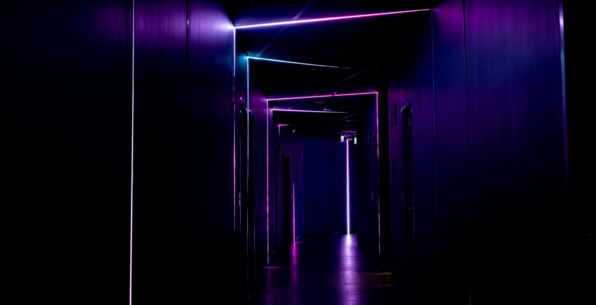 Blacked-out escape room corridor lit by magenta neon at The Great Escape, Melbourne CBD