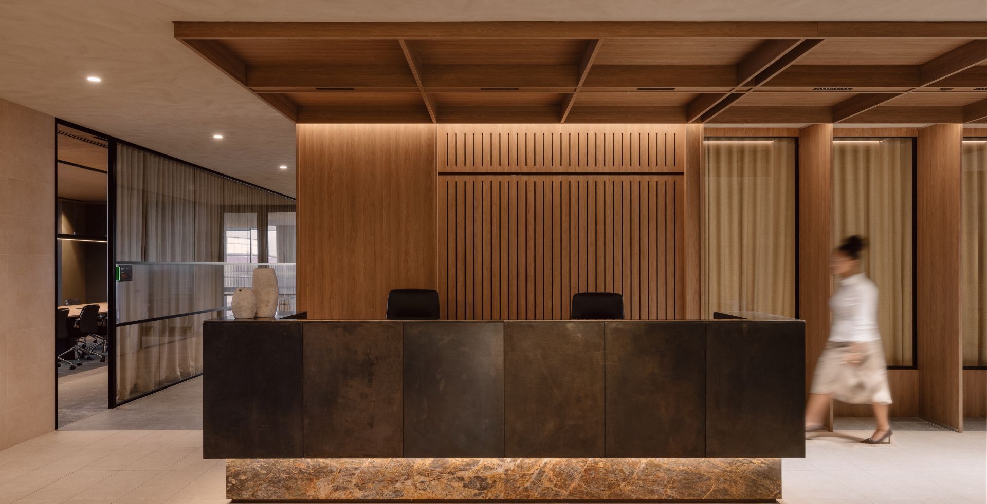 Bronze and marble reception desk beneath a coffered timber ceiling at the Amicus-delivered Mazzei office