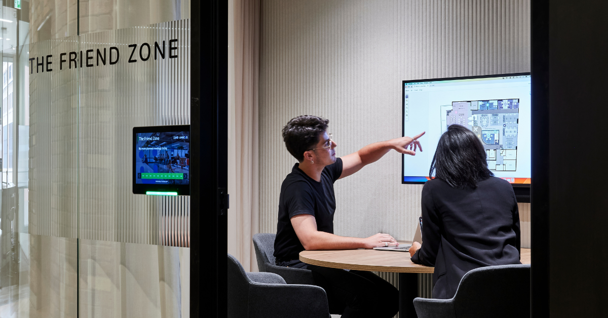 People looking at office design plans on a large screen