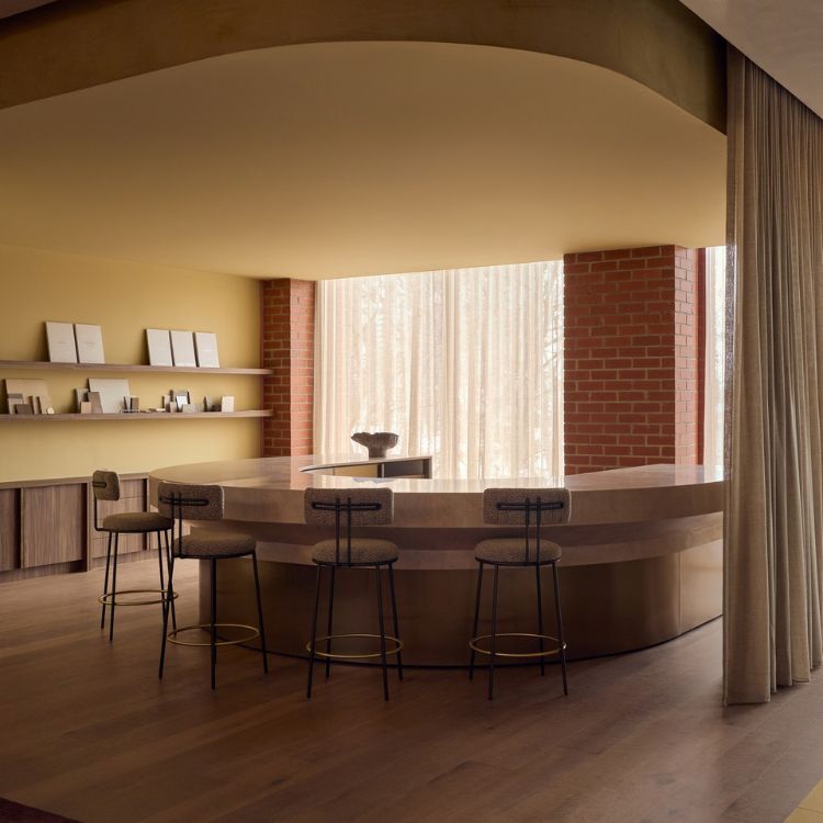 Curved counter with upholstered bar stools and display shelves at the Lowe Living headquarters