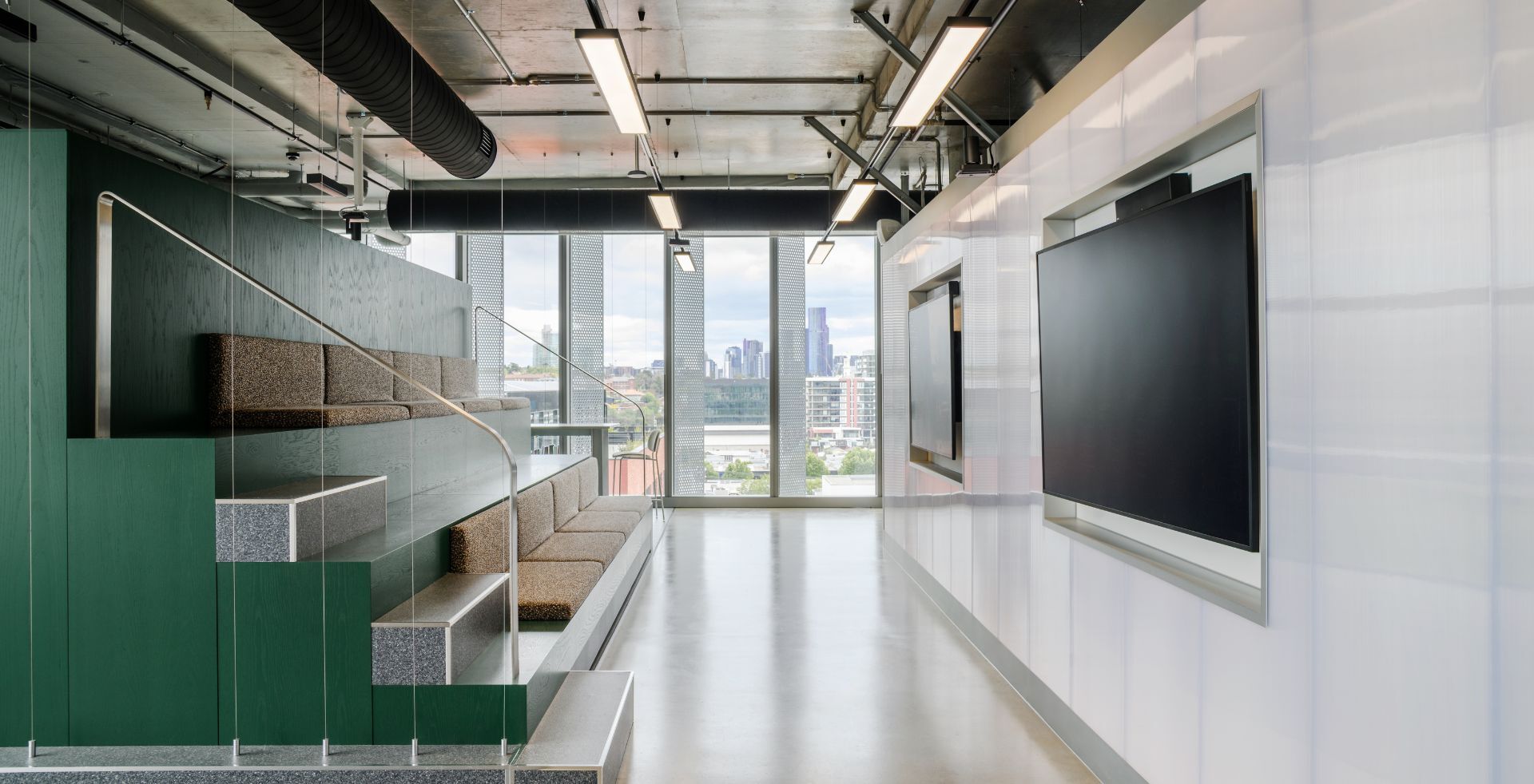 Tiered seating and presentation screens overlooking the Melbourne skyline