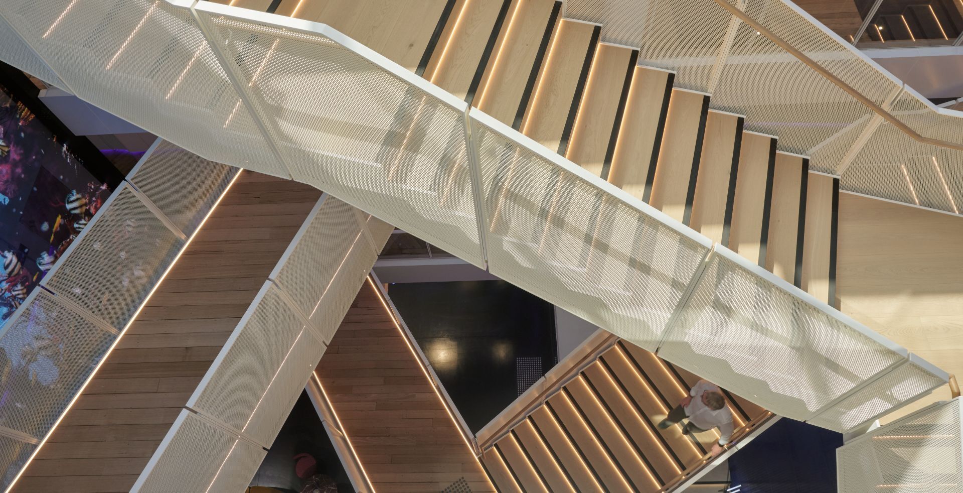 Intersecting feature staircase with perforated metal balustrades