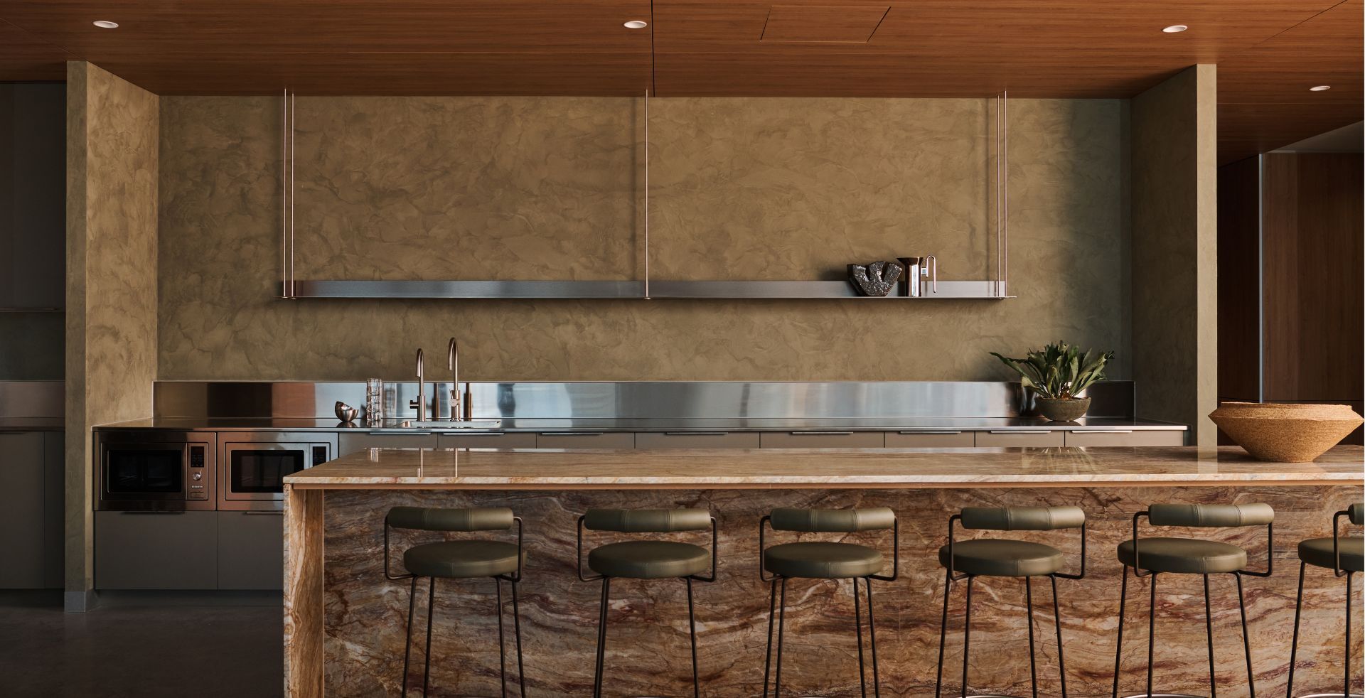 Stone island kitchen with timber ceiling, bar seating and integrated joinery in a refined workplace setting.