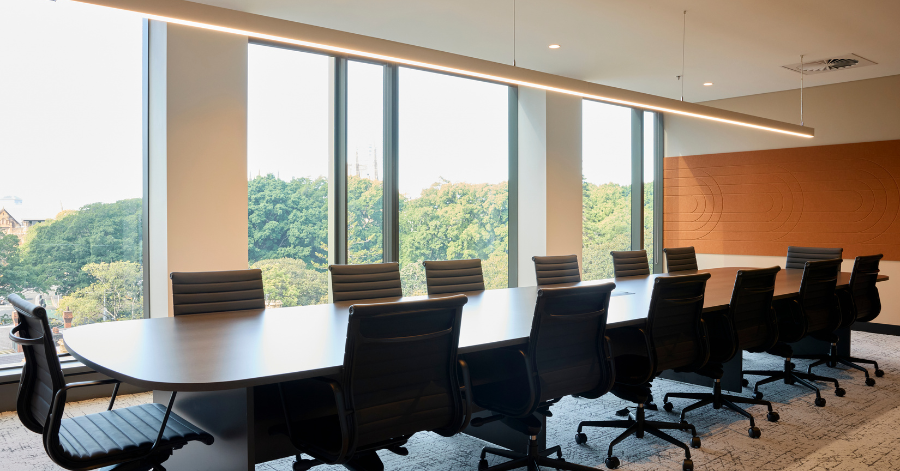 A spacious, modern boardroom overlooking park trees inside the Kyko Spec Suite.