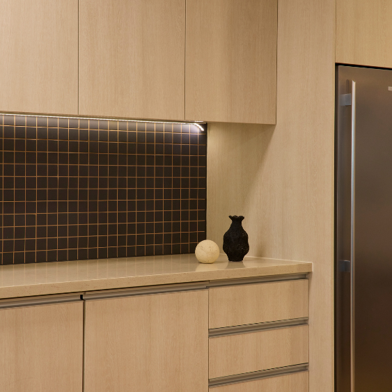 A contemporary kitchen splashback and timber cabinetry inside the Kyko Spec Suite.