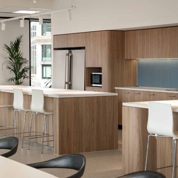 Diabetes Australia's kitchen area with timber cabinetry, white island counters, and high bar stools