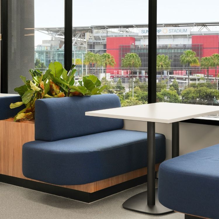 Blue fabric booth seating and a white table positioned in front of a window for Diabetes Australia's office