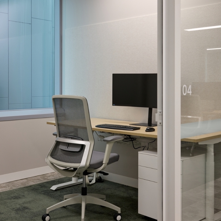 Private workspace pod featuring an ergonomic mesh chair and adjustable desk.