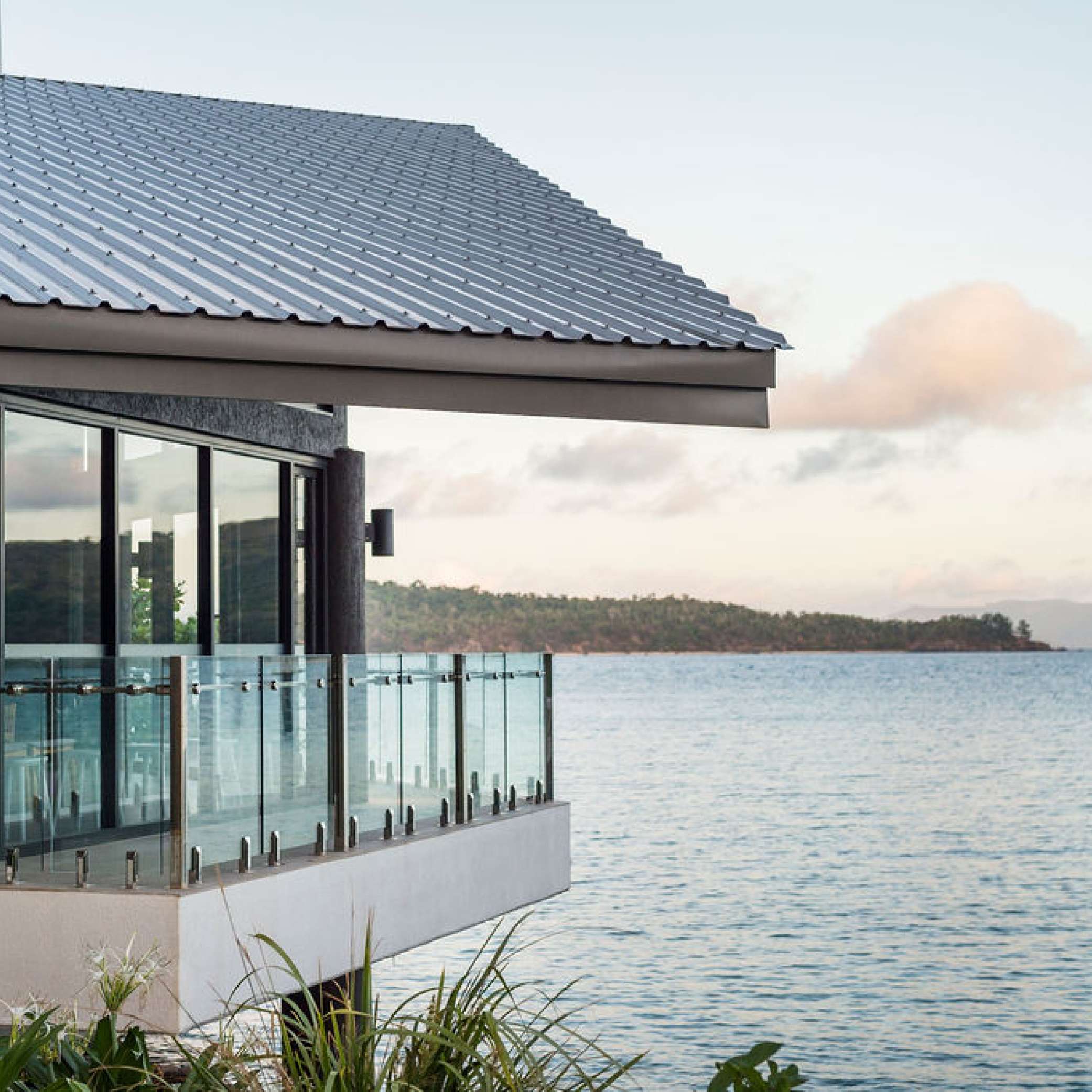 Balcony looking out onto scenic landscape surrounded by sea.