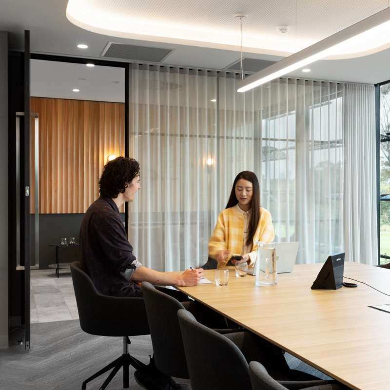 Man and woman meeting in minimalistic conference room.