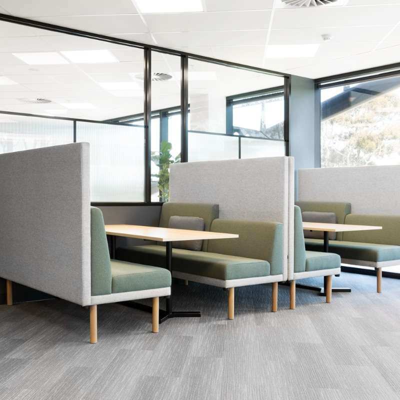 Modern booths with wooden tables for McArthur employee use.